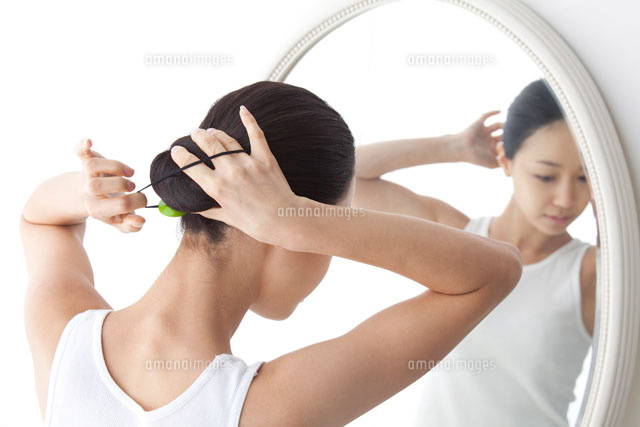 鏡の前で髪を結う女性[02441000138B]｜ 写真素材・ストックフォト・画像・イラスト素材｜アマナイメージズ