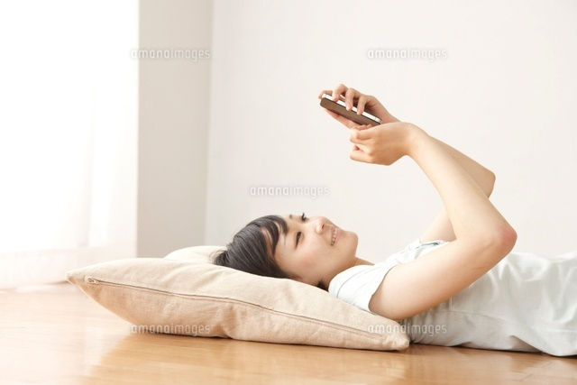 リビングの床でスマートフォンで調べ物をする女性
(c)Doable/a.collectionRF