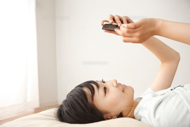 リビングの床でスマートフォンで調べ物をする女性
(c)Doable/a.collectionRF