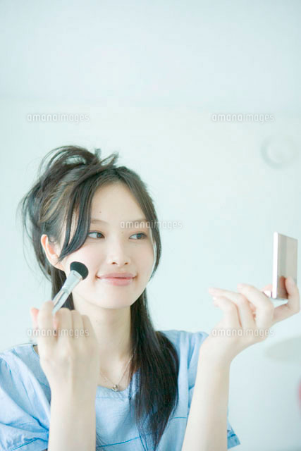コンパクトミラーを見ながら化粧をする若い女性
(c)absodels RF