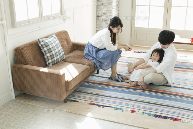部屋でくつろぐ若い夫婦と子供
(c)absodels RF