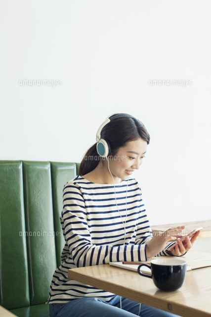 カフェで音楽を聴く20代女性
(c)absodels RF