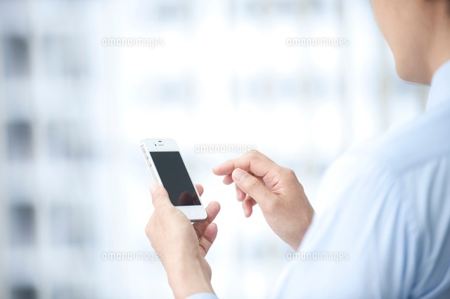 スマホを使うビジネスマン[10248005359]｜ 写真素材・ストックフォト・画像・イラスト素材｜アマナイメージズ