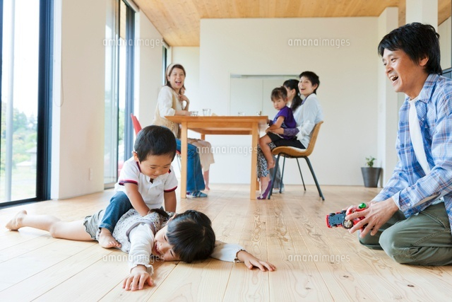 床で遊ぶ父親と子供とティータイムの母親達[10272002681]｜ 写真素材・ストックフォト・画像・イラスト素材
