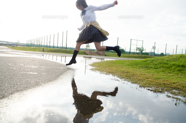 水たまりをジャンプする女子学生
(c)Emi Komagata/a.collectionRF
