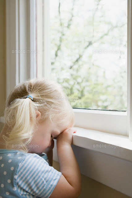 Sad little girl by window
(c)Image Source