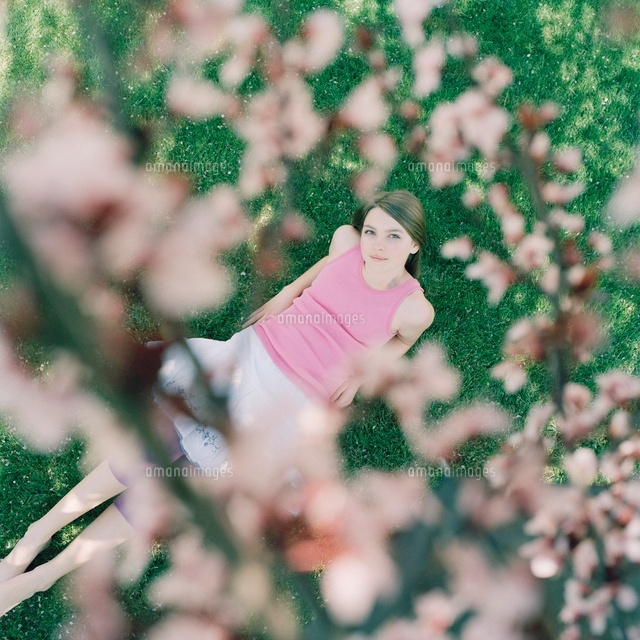 A girl lying on grass looking up at cherry tree blossoms
(c)Heidi Yount/fstop