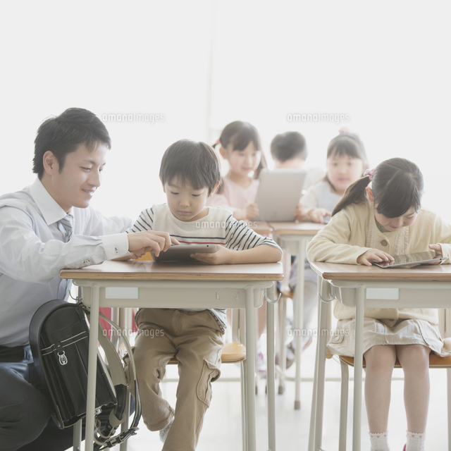 タブレットPCで勉強をする小学生と先生
(c)visual supple