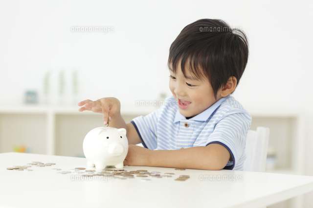 貯金箱にお金を入れる男の子
(c)mon printemps