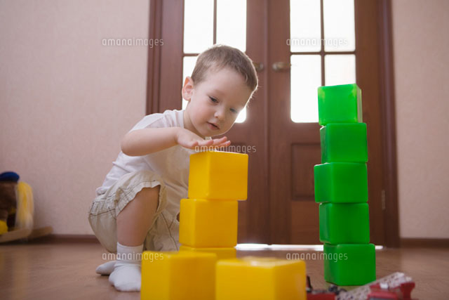 Young boy plays with green and yellow building bricks
(c)moodboard