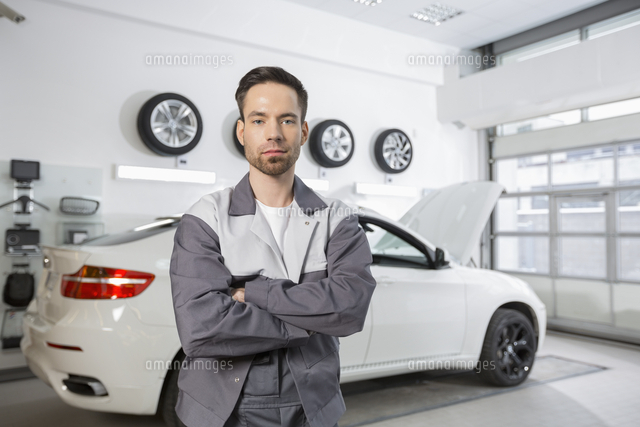 Portrait of confident male automobile mechanic standing in front of car at workshop
(c)moodboard