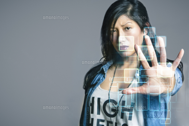 Serious mid adult woman touching futuristic computer screen over gray background
(c)moodboard