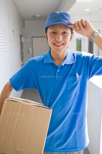 段ボール箱を持つ宅配便屋の男性
(c)DAJ