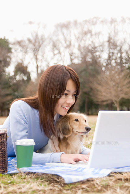 パソコンを操作する女性と犬
(c)DAJ