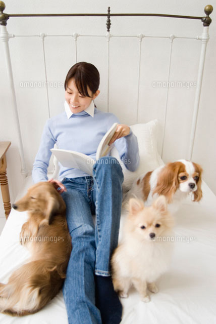 ベッドでくつろぐ犬と女性
(c)DAJ