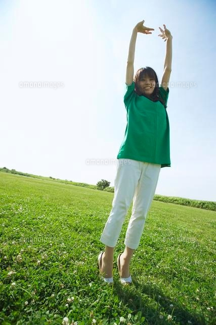 グリーンの芝生と青空に背伸びする緑の服の女性
(c)Doable/a.collectionRF