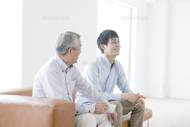 ソファに座って話す笑顔の父親と息子
(c)absodels RF