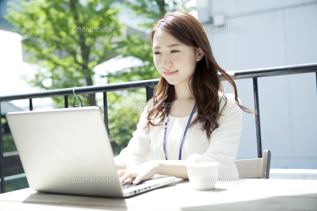 屋外でパソコンを使う20代女性
(c)absodels RF