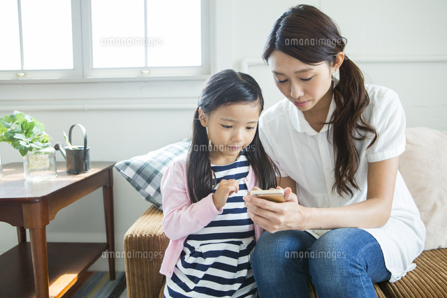 スマホを見る母と子ども
(c)absodels RF
