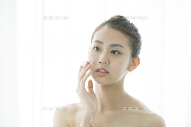 頬に手を当てるナチュラルメイクの20代女性
(c)absodels RF