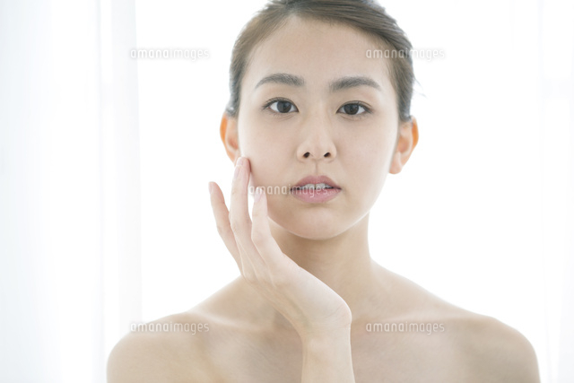 頬に手を当てるナチュラルメイクの20代女性
(c)absodels RF