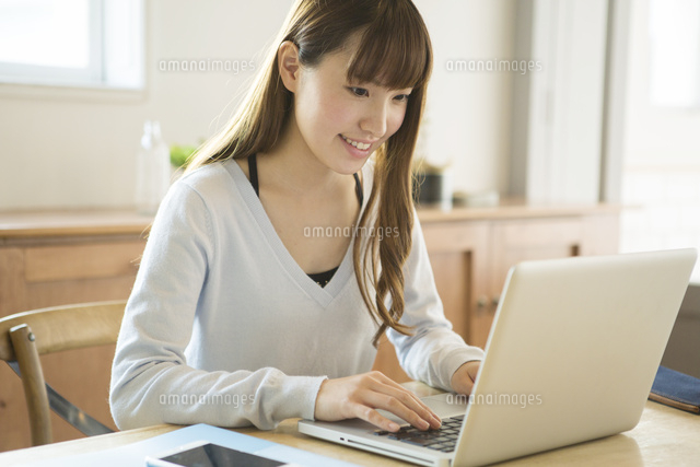 笑顔でパソコンを操作する20代女性
(c)absodels RF