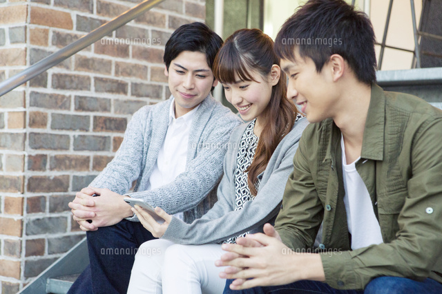 一つのスマホを眺める20代男女3人
(c)absodels RF