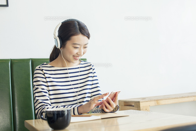 カフェで音楽を聴く20代女性
(c)absodels RF