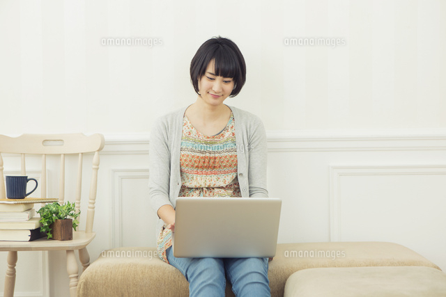 部屋でパソコンを使う20代女性
(c)absodels RF