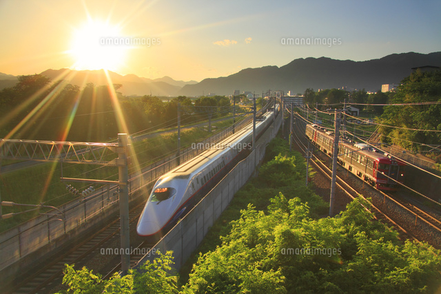 北陸新幹線E2系としなの鉄道の電車と夕日
(c)Mitsushi Okada/a.collectionRF