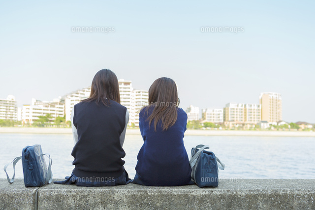 防波堤に座る2人の日本人女子高生
(c)Pholdar nine/a.collectionRF