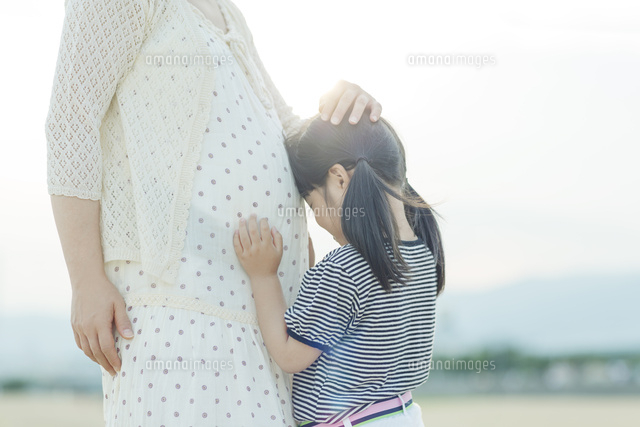 妊婦の母のお腹に顔をつける娘
(c)Pholdar nine/a.collectionRF