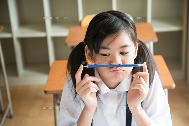 鼻の下に鉛筆を挟んでいる小学生の女の子
(c)Emi Komagata/a.collectionRF