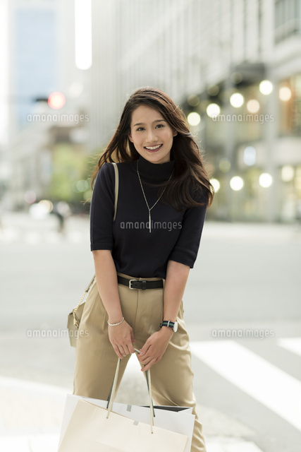 ショッピングバッグを持つ若い女性
(c)RYO