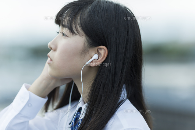 イヤホンで音楽を聴く女子学生
(c)RYO