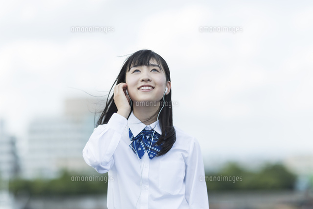 イヤホンで音楽を聴く女子学生
(c)RYO