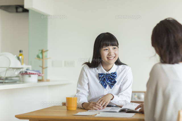 テーブルで資料を見ながら会話をする母娘
(c)RYO