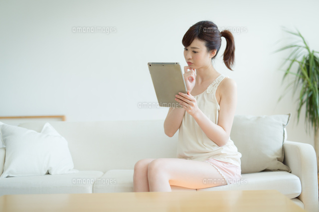 ソファに座りタブレットPCを使う女性
(c)forty-one/amanaimagesRF