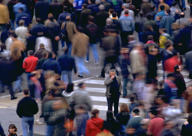 crowd-walking-by-man-standing-in-opposite-direction-11001026658