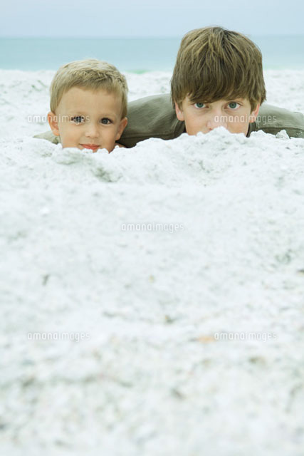 Two brothers peeking over sand at camera
(c)Odilon Dimier/Photo Alto