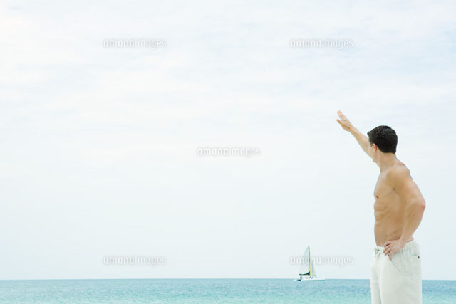 Man waving at sailboat in distance
(c)Sandro Di Carlo Darsa/Photo Alto
