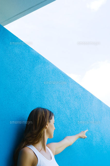 Female in front of blue wall, pointing
(c)Sandro Di Carlo Darsa/Photo Alto