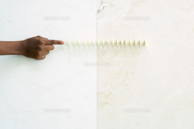 Child reaching toward lined up dominoes
(c)Sandro Di Carlo Darsa/Photo Alto