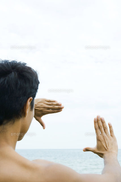 Man looking at sea through finger frame
(c)Sandro Di Carlo Darsa/Photo Alto