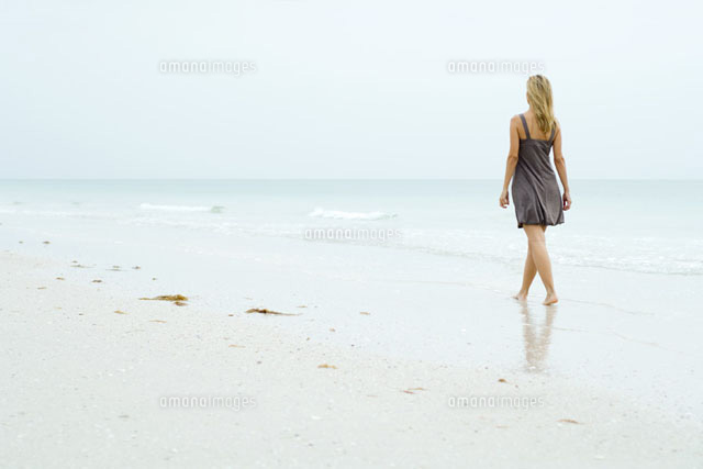 Woman in sundress walking along beach
(c)Eric Audras/Photo Alto