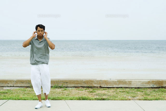 Man standing and listening to headphones
(c)Eric Audras/Photo Alto