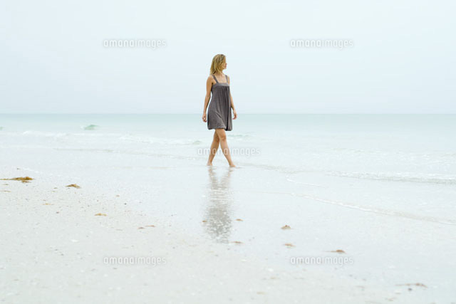 Woman in sundress walking along beach
(c)Eric Audras/Photo Alto