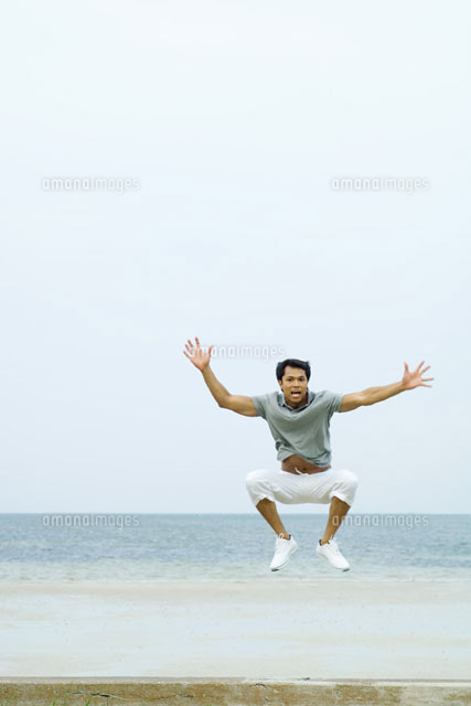 Man jumping in the air at the beach
(c)Eric Audras/Photo Alto