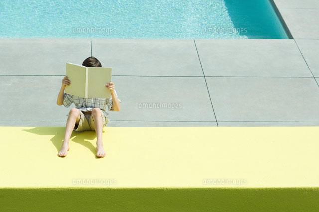 Boy reading beside swimming pool
(c)Eric Audras/Photo Alto