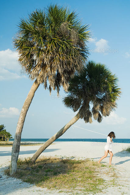 Woman pulling palm tree with rope
(c)Milena Boniek/Photo Alto